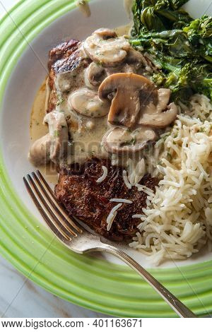 Grilled Club Steak With Creamy Marsala Wine Mushroom Sauce And Sides Of Rice And Broccoli Rabe