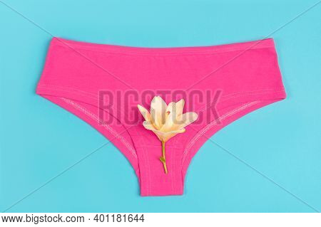 Pink Underpants And Flower On Blue Background, Close Up. Concept Keep Your Vagina Healthy And Happy.