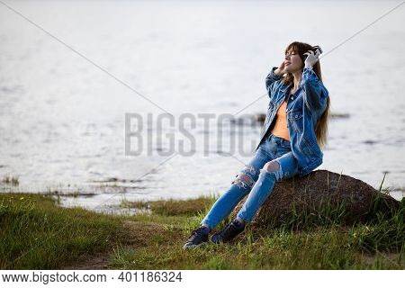 Happy Young Woman Dancing In Headphones On The Shore Of The Bay Sun Sunny Spring Day