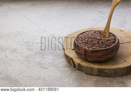 Wooden Bowl With Flax Seeds On A Concrete Background, A Dietary Cereal Ingredient For Granola That R