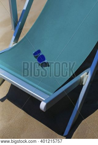 Turquoise Sun Lounger, Chaise Longue Textile Chair Close Up With Blue Sunglasses On Sand, Vacation, 