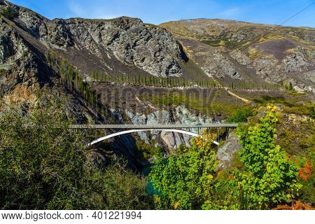 The river with bright green water. River and old bridge Kawarau between Queenstown and Cromwell. Incredible Adventures in New Zealand. The concept of extreme, active and photo tourism