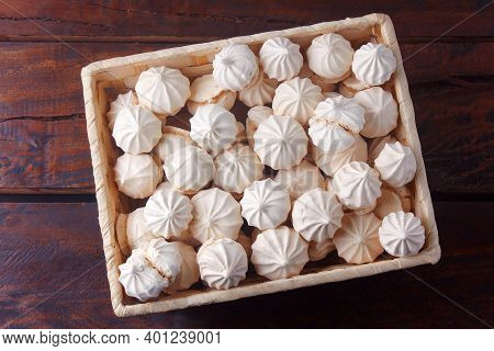 Sigh Or Homemade Meringue Is A Sweet Made From Egg Whites, Sugar And Lemon In The Basket On Wooden T