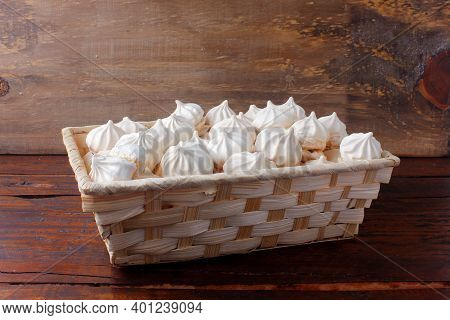 Sigh Or Homemade Meringue Is A Sweet Made From Egg Whites, Sugar And Lemon In The Basket On Wooden T