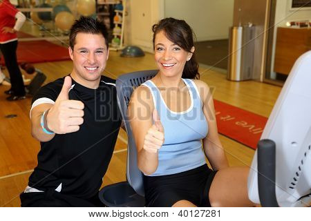 Trainer und Frau auf Fahrrad showing Thumbs up