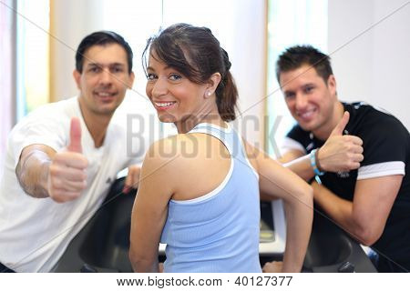 Gruppe von drei Freunden auf Laufband Daumen aufgeben