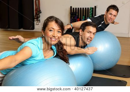 zwei MÃ¤nner und eine Frau, die AusÃ¼bung auf Gymnastik-BÃ¤lle