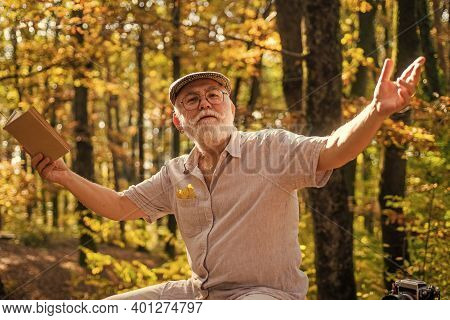 Hes Walking Encyclopedia. Elderly Man Hold Book In Nature. Pensioner Read Book On Autumn Day. Leisur