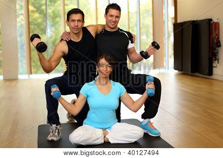 Gruppe, die mit Hanteln im Fitnessstudio