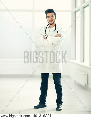 In Full Growth. Smiling Therapist Standing By The Hospital Windo