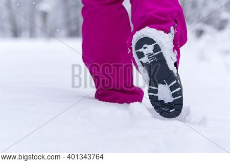 Women Hiking In Winter Forest By Snow In Hiking Shoes Boots. Winter Hiking.