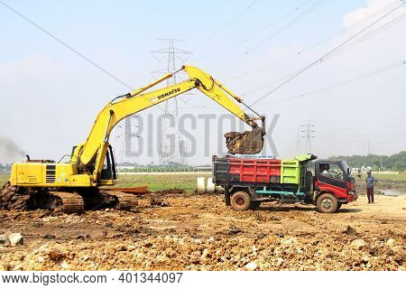 Bekasi, 12/7/2020. A Heavy Equipment Is Moving Land Onto A Truck During A Housing Or Residential Dev