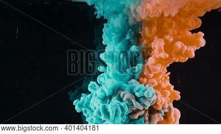 Splash Of Colored Ink In Water On Black Background. Action. Two Colors Are Mixed In Water On Isolate