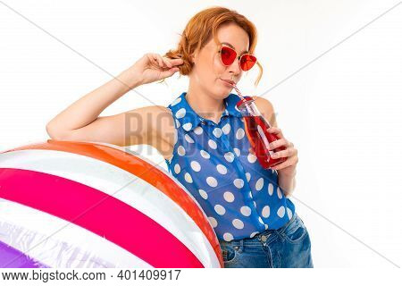 Beautiful Girl In Sunglasses Holds An Inflatable Big Ball For Swimming And A Glass Cup With A Straw 