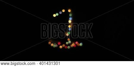 Number One (1) Made With Multicolored Christmas Lights . Blurred Bokeh Abstract Isolated On A Black 