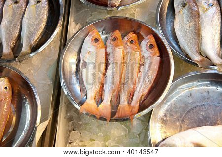 Peixes inteiros e frescos são oferecidos no mercado de peixe na Ásia
