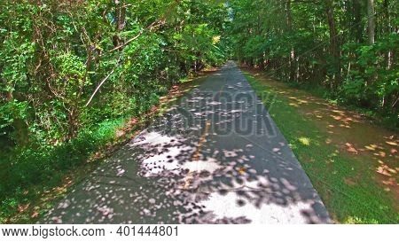 Paulding County, Ga Usa - 06 11 20: Paved Trail Straight Ahead View And Green Foliage In The Summer 