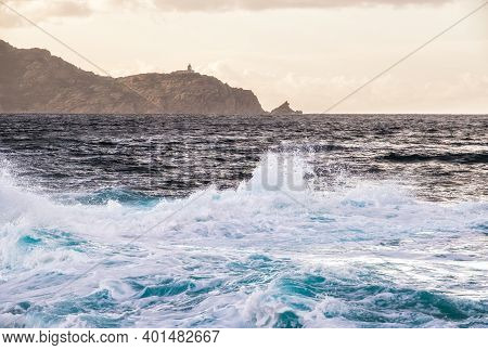 Stormy Mediterranean Sea At Punta Caldanu Near Lumio In The Balagne Region Of Corsica With The Light