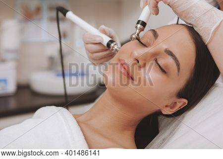 Stunning Young Woman With Flawless Skin Enjoying Facial Treatment At Cosmetology Clinic. Relaxed Bea