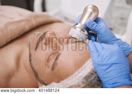 Close Up Of A Mature Bearded Man Relaxing At Beauty Salon, Getting Ultrasound Cavitation Treatment. 