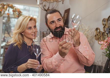 Happy Beautiful Woman Enjoying Shopping For Glassware With Her Handsome Husband. Mature Married Coup