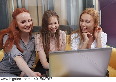 Team Of Cheerful Businesswomen Discussing Strategy At Modern Office