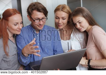 It Department Expert Helping His Female Colleagues, Showing Something On The Laptop
