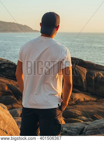 The Picture Shows A Back View Of An Unrecognizable Teenager With Your Hands In Your Pockets Watching