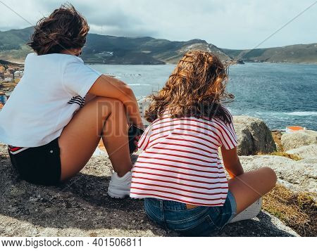 The Picture Shows A Back View Of Two Little Girls Unrecognizable Looking At A Landscape With Sea And