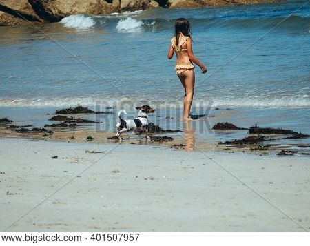 The Picture Shows A Vertical Photo Of A Back View Of A Little Girl In A Bikini On The Beach Looking 