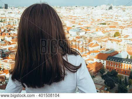 The Picture Shows A Back View Of A Little Girl Looking At The Skyline Of The City Of Madrid On A Sun
