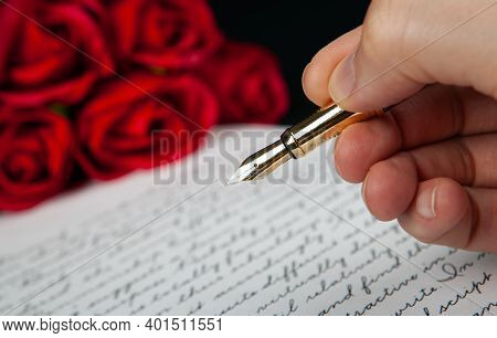 Fountain Pen In The Hand On Letter With Text And Red Roses Close Up