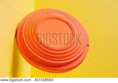 Clay Disc Target For Skeet Shooting Flying Against The Colorful Yellow Background. Clay Pigeon Shoot