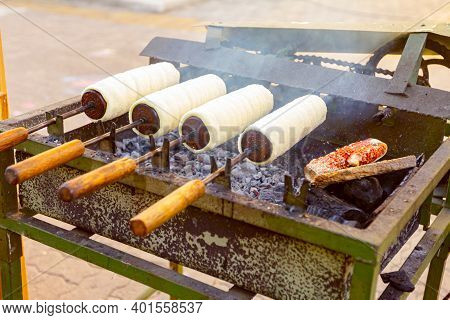 Traditional Hungarian Spit Cinnamon, Chimney Cake Is Rotate For Equal Baking Over Glowing Charcoal E
