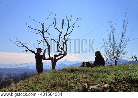 Mother And Son Sit At A Vantage Point To Admire The Monviso Alp During A Walk In The Countryside. Hi