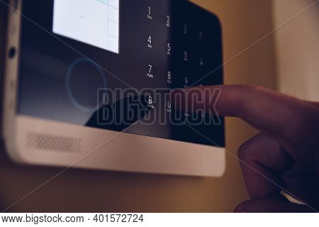 Man Arming Home Security Alarm. Home Alarm System