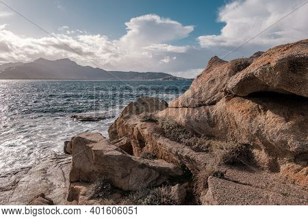 The Rocky Coastline Of Corsica With The Citadel Of Calvi In The Distance