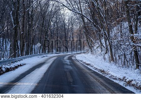 Winding Snow Covered Road In Rural Minnesota During Winter, Lined With Trees