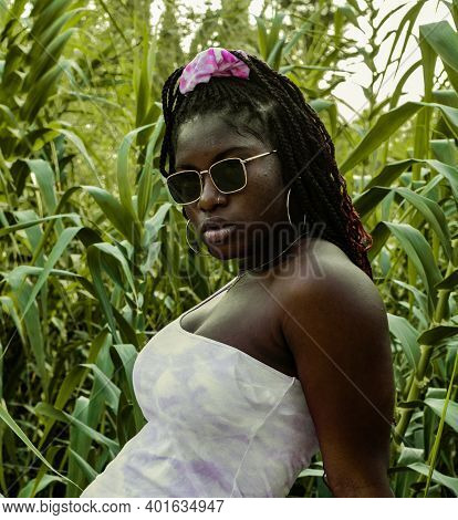The Young African Woman In A White Dress Is Smiling With Her Back To The Camera