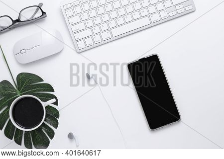 Minimal Office Desk Table Top View With Smart Phone, Earphones, Keyboard Computer, Mouse, Glasses,  