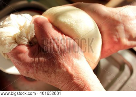 Process Of Making Homemade Ricotta Cheese. Close-up Of Female Hands With Freshly Made Cottage Cheese