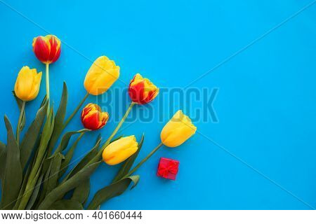 Bouquet Of Yellow And Red Tulips On A Blue Background. International Women Is Day 8 March. Copy Spac