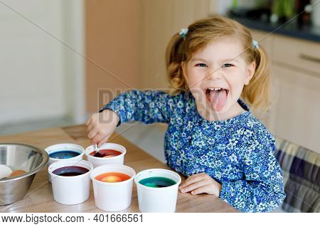 Excited Little Toddler Girl Coloring Eggs For Easter. Cute Happy Child Looking Surprised At Colorful