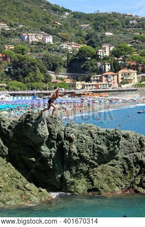 Bonassola, Italy - Summer2020: Guys Dive From A Cliff Into The Sea Of The Five Lands. High Quality P