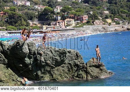 Bonassola, Italy - Summer2020: Guys Dive From A Cliff Into The Sea Of The Five Lands. High Quality P