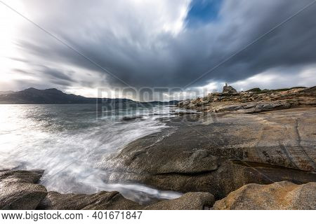 Waves Washing Onto The Rocky Coastline At Punta Caldanu Near Lumio In The Balagne Region Of Corsica 