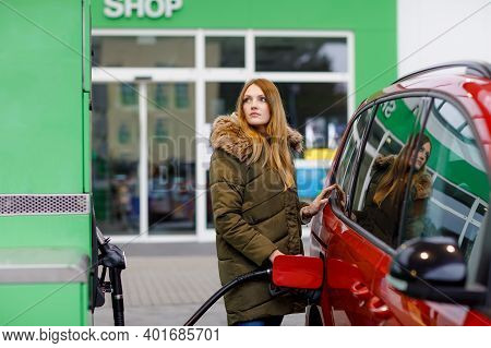 Young Caucasian Woman At Self-service Gas Station, Hold Fuel Nozzle And Refuel The Car With Petrol, 