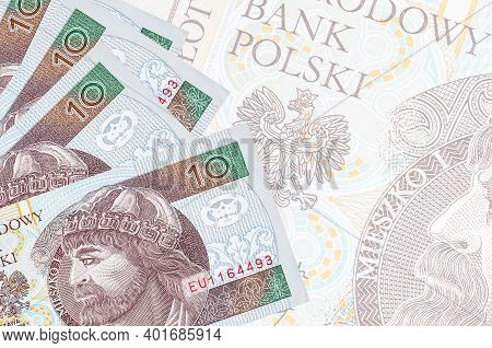 10 Polish Zloty Bills Lies In Stack On Background Of Big Semi-transparent Banknote. Abstract Busines