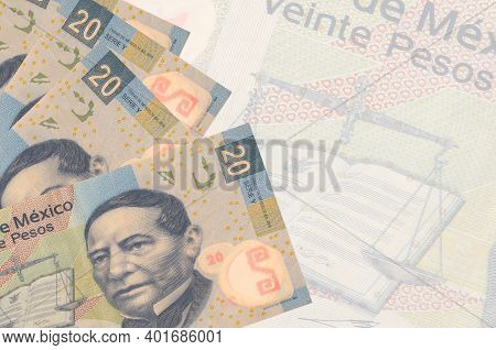 20 Mexican Pesos Bills Lies In Stack On Background Of Big Semi-transparent Banknote. Abstract Busine