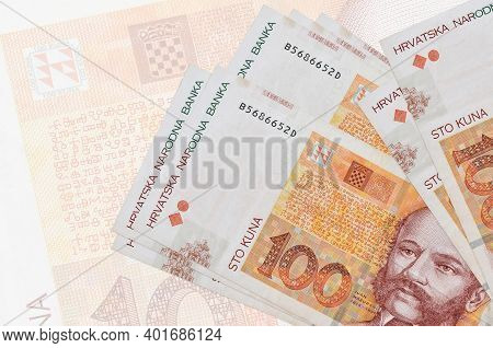 100 Croatian Kuna Bills Lies In Stack On Background Of Big Semi-transparent Banknote. Abstract Prese